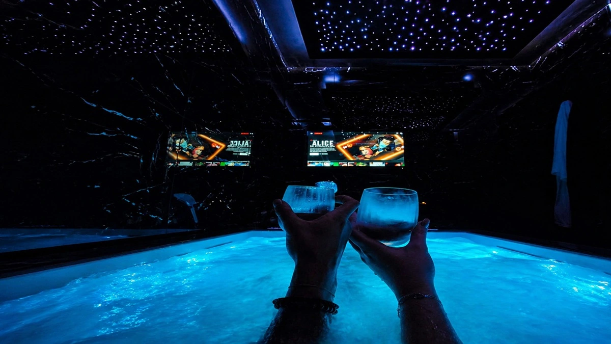 celebrer-demande-en-mariage-jacuzzi-privatif Un couple trinque dans un jacuzzi privatif sous un ciel étoilé pour célébrer une demande en mariage en Normandie